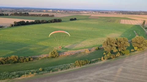 Motorized paragliding pilot flying low above ground enjoying powered flight 库存影片 334684031