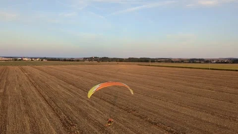 Motorized paragliding pilot flying low above ground enjoying powered flight 库存影片 334684041