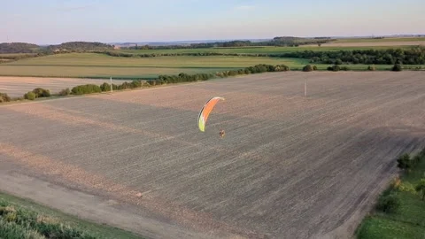 Motorized paragliding pilot flying low above ground enjoying powered flight 库存影片 334684043