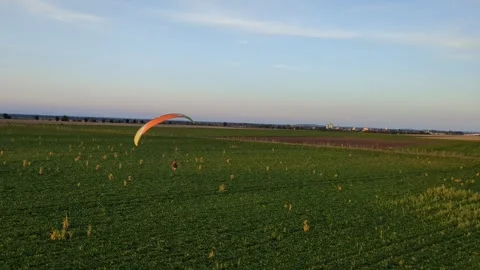 Motorized paragliding pilot flying low above ground enjoying powered flight 库存影片 334684047