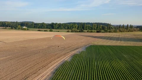 Motorized paragliding pilot flying low above ground enjoying powered flight 库存影片 334685739