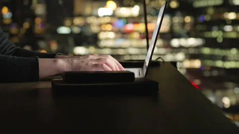 Motorized rising shot of using working with computer at night, city background Stock-Footage 194521320