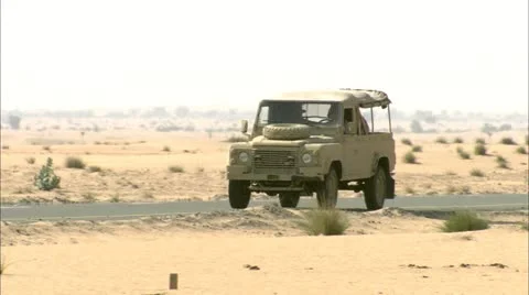 Motors - Army Jeep driving into the desert Stock Footage
