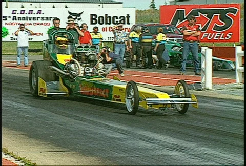 Motorsports, drag race, old style front engine top fuel rail launch, pan close Stock Footage