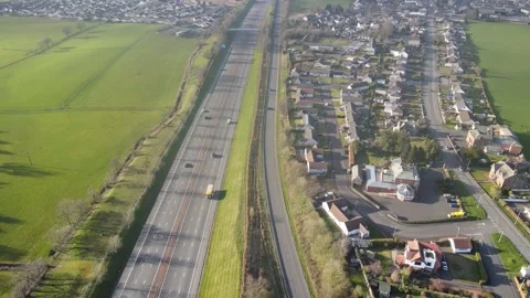 Motorway and A road with green fields and town Stock Footage 336999620