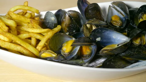 Moules frites  cooked mussels in shells with fries  in a bowl, ready to eat. Stock Footage 200904261