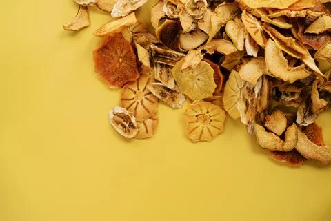 Mound of fruit chips in the top corner on a yellow background Stock Photos