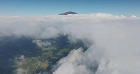 Mount Abang volcano peak emerging above clouds in Bali 库存照片