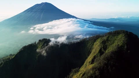 Mount Agung Volcano with Rolling Clouds Over Ridge and Lush Green Slopes Aerial Stock Footage 334626051