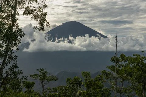 Mount Agung volcano  view framed by the trees in Bali island Stock Photos