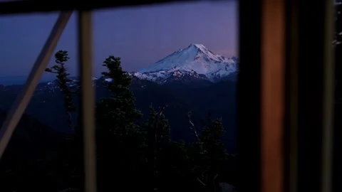 Mount Baker at sunset, shot through the window of a fire lookout tower Stock Footage 344990757