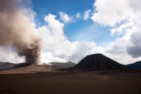 Mount Batok sitting next to the active volcano mount Bromo, with blue skies. Stock Photos