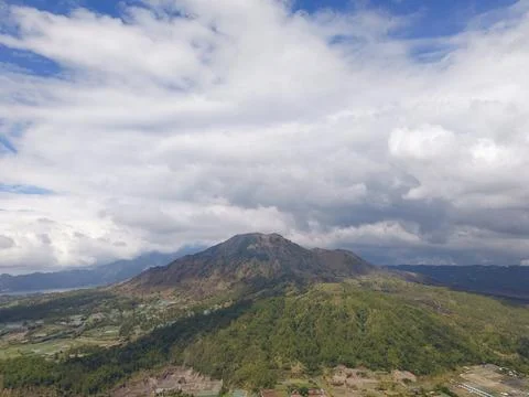 Mount Batur Volcano with Dramatic Clouds and Green Valleys in Bali 写真素材