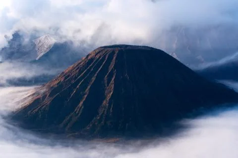 Mount Bromo, an active volcano surrounded by white clouds of mist. Stock Photos