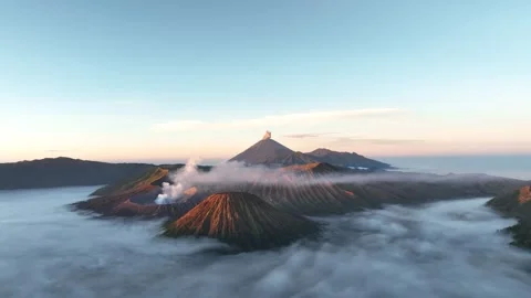 Mount Bromo With Mount Semeru Erupting In The Background, Surrounded By Clouds Video stock 344279347