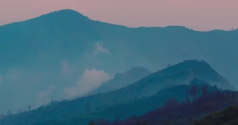 Mount Bromo Volcano Silhouette with Moving Fog at Sunset Aerial Stock Footage 329596848