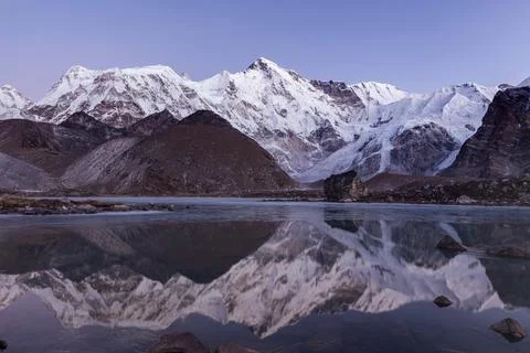 Mount Cho Oyu reflection in water. View from the base camp. Early pinkish m.. Stock Illustration