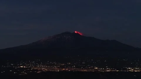 Mount Etna erupting volcanic summit glowing deep red lava above Catania city at Видео 328644399