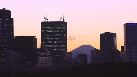 Mount Fuji appears in the sunset among the high-rise buildings at Tokyo Vidéo 129049255