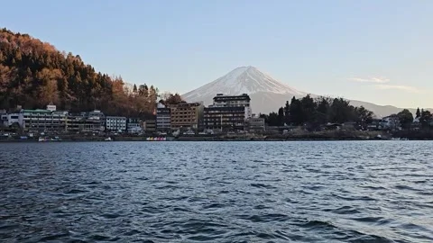 Mount Fuji rises above lakeshore hotels on Lake Kawaguchi, Fujikawaguchiko, Stock Footage 344532375