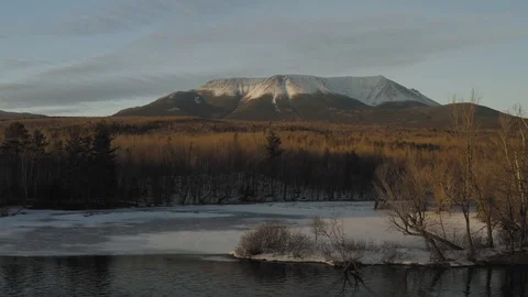 Mount Katahdin covered in snow ascending aerial above woods by Penobscot Stock Footage