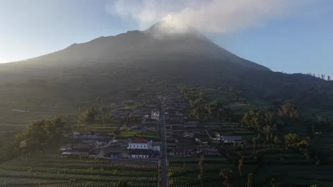 Mount Merapi dominates the horizon above a green countryside. Stock Footage 338429092