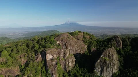 Mount Merapi seen afar from the peak of the Nglanggeran Ancient Volcano Stock Footage 347535198