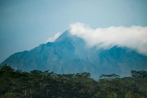 Mount Merbabu Peak Partially Covered by Clouds Above Tropical Forest Under .. Foto stock