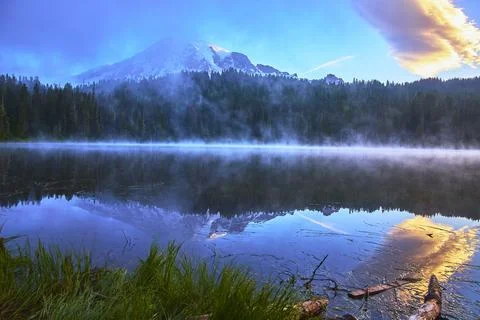 Mount Rainier Reflected at Sunrise Over Misty Lake With Forest and Colorful S Stock Photos