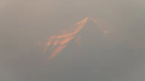 Mount Robson hidden by smoke as sun fades from snowy peak 8K Video stock 111133136