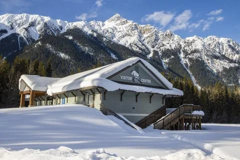 Mount Robson Visitor Centre surrounded by snow-covered mountains during win.. Stock Photos