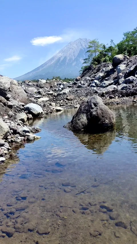 Mount Semeru during the day with a river foreground Stock Footage 283421132