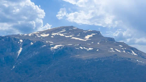 Mount top covered by a snow under blue cloudy sky Stock Footage 257605760