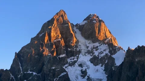Mount Ushba glowing in close view at sunrise above snowfields Stock Footage 343771168
