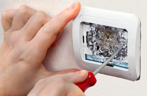 Mount wall light switch, close-up of human hand with screwdriver. Stock Photos