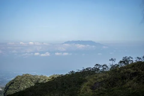 Mount Wilis covered in clouds is seen from the distance on the slopes of Mo.. Stock Photos