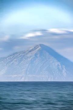 Mountain and clouds in motion  over the sea Stock Photos