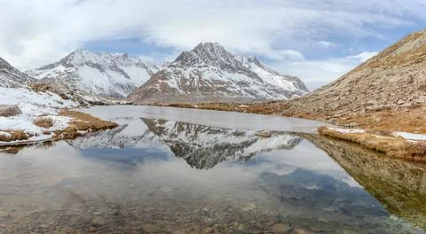 Mountain and clouds reflected in water of a serene lake Foto stock