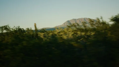 Mountain and forest seen from moving vehicle on a sunny day Stock Footage 106330471
