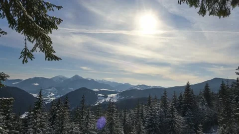 Mountain and hilly winter landscape from the forest, the sun moving across the Video stock 236250031
