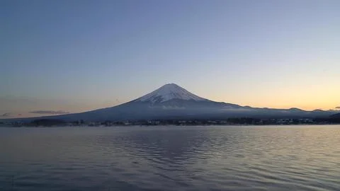 Mountain and lake scene at sunset with snow-capped peak Stock Photos