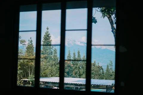 Mountain and trees framed by a window, showcasing a serene and lush natural.. Foto stock