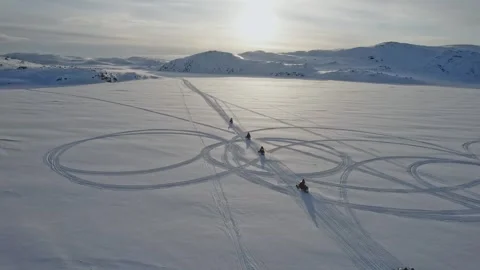 Mountain Backdrop With Synchronized Snowmobile Maneuvers During Sunset on snow Stock Footage 339617937