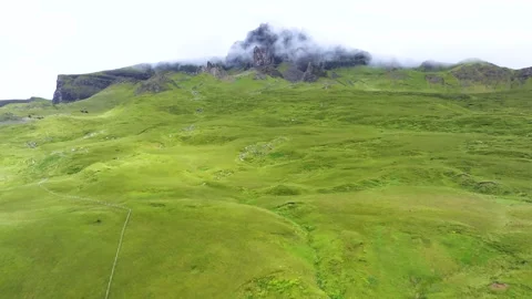 A mountain is in the background of a green field Stock Footage 306561130
