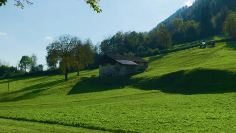 Mountain Barn with Tractor in Meadow and Green Alpine Valley Stock Footage 320188306