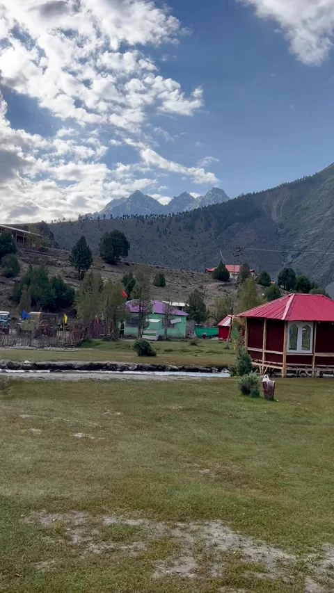 Mountain Base Camp with Colorful Cabins and Tents under Dramatic Cloudy Sky Stock Footage 330136296