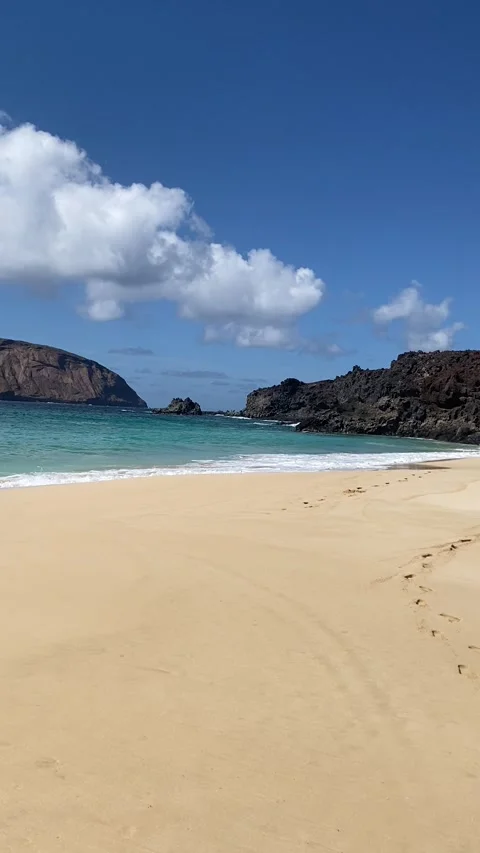 Mountain Bermeja and wild waves at Playa de las Conchas of La Graciosa Stock Footage 310574036