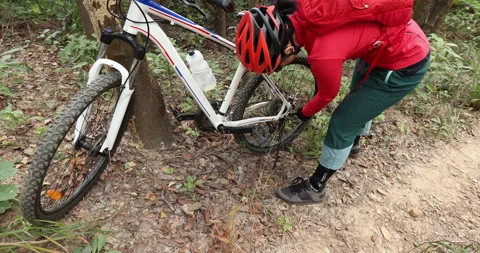 Mountain biker adjust the chains cycling on forest trail, slow motion Stock Footage 146620545