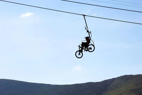 Mountain biker climbs on the cable car. Stock Photos