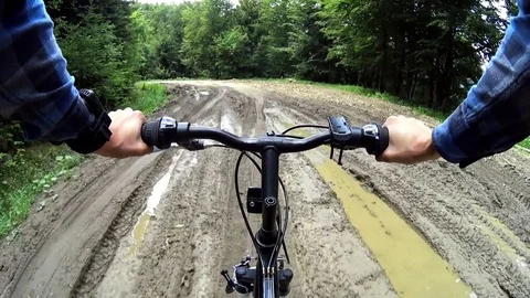Mountain biker cycling through muddy dirt road in Bieszczady, Poland Stock Footage 80780347